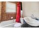 Cozy bathroom featuring a tiled wall, toilet, sink, and bathtub with a privacy window at 545 S Green St, Statesville, NC 28677