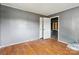 Bedroom featuring hardwood floors, gray walls, an open closet, and freshly painted interior at 545 S Green St, Statesville, NC 28677