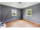 Bright bedroom with hardwood floors, two windows, and freshly painted gray walls awaiting personalization at 545 S Green St, Statesville, NC 28677