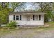 Quaint one-story home with a small front porch and mature trees, offering a cozy curb appeal at 545 S Green St, Statesville, NC 28677