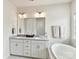 Bright bathroom featuring a double sink vanity, soaking tub, and modern fixtures at 6433 Raffia Rd, Charlotte, NC 28277