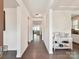 Inviting hallway featuring hardwood floors, neutral paint, and access to various rooms at 6433 Raffia Rd, Charlotte, NC 28277