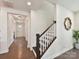 Welcoming hallway with hardwood floors, staircase, and decorative mirror at 6433 Raffia Rd, Charlotte, NC 28277