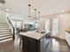 Open-concept kitchen featuring a large island with seating and a seamless flow to the dining and living areas at 6433 Raffia Rd, Charlotte, NC 28277