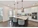 Bright kitchen with white cabinets, a large island with seating, and stainless steel appliances at 6433 Raffia Rd, Charlotte, NC 28277