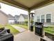Relaxing covered patio with an outdoor grill and patio heater overlooking a private fenced yard at 6433 Raffia Rd, Charlotte, NC 28277