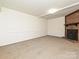 Neutral carpeted basement features a brick fireplace with mantel and white trim at 6745 Thermal Rd, Charlotte, NC 28211