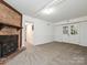 Spacious carpeted basement with brick fireplace and white trim leading to walkout doors at 6745 Thermal Rd, Charlotte, NC 28211