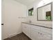 Neutral bathroom featuring a gray granite countertop, white cabinetry, and black framed mirror at 6745 Thermal Rd, Charlotte, NC 28211