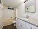 Bathroom features a granite countertop, framed mirror, window and shower with tub at 6745 Thermal Rd, Charlotte, NC 28211