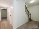 Hallway featuring a staircase with wooden banister, neutral carpet and two white panel doors at 6745 Thermal Rd, Charlotte, NC 28211