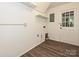 Bright laundry room with light vinyl flooring, white walls and shelves at 6745 Thermal Rd, Charlotte, NC 28211