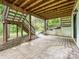 Covered concrete patio with wooden beam ceiling, supporting posts, and stairs to backyard at 6745 Thermal Rd, Charlotte, NC 28211