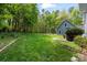 Serene backyard with lush lawn, mature trees, and garden beds, providing a private oasis at 705 Normandy Rd, Mooresville, NC 28117