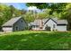 Expansive backyard with well-manicured lawn, mature trees, and a large deck perfect for entertaining at 705 Normandy Rd, Mooresville, NC 28117