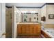 This bathroom features a double vanity, shower and large soaking tub with tiled walls and floor at 705 Normandy Rd, Mooresville, NC 28117