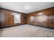 Inviting bedroom with wood paneling, neutral carpet, and a window offering plenty of natural light at 71 14Th Se St, Hickory, NC 28602