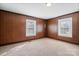 Spacious bedroom featuring wood paneling, plush neutral carpet, and bright windows at 71 14Th Se St, Hickory, NC 28602