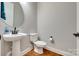 Powder room featuring pedestal sink, modern fixtures, and hardwood flooring at 7157 Sumters Camp Trl, Indian Land, SC 29707