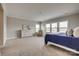 Spacious bedroom featuring a dresser, large windows and a comfortable bed with a blue cover at 7157 Sumters Camp Trl, Indian Land, SC 29707