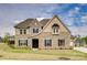 Charming two-story home featuring a stone facade, well-manicured lawn, and classic architectural details at 7157 Sumters Camp Trl, Indian Land, SC 29707