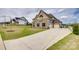 Beautiful two-story home featuring a stone facade, manicured lawn, and a long driveway leading to an attached garage at 7157 Sumters Camp Trl, Indian Land, SC 29707