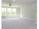Bright, neutral bedroom with large windows offering natural light and ceiling fan at 7185 Chamberlain Dr, Harrisburg, NC 28075