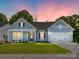 Single-Gathering home with blue siding, white trim, and well-maintained lawn at dusk at 7185 Chamberlain Dr, Harrisburg, NC 28075