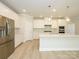 Spacious kitchen featuring white cabinetry, stainless steel appliances, and an island with quartz countertop at 7185 Chamberlain Dr, Harrisburg, NC 28075