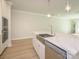 Close-up on a kitchen island with quartz countertop, stainless steel dishwasher, and designer faucet at 7185 Chamberlain Dr, Harrisburg, NC 28075
