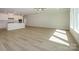Spacious living room with light wood flooring and a view into the modern kitchen at 7185 Chamberlain Dr, Harrisburg, NC 28075