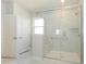 Modern glass-enclosed shower with marble tile and built-in bench, complemented by sleek fixtures at 7185 Chamberlain Dr, Harrisburg, NC 28075