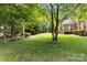 Well-manicured backyard featuring a lush lawn and mature trees offering privacy and shade at 7302 Yellowhorn Trl, Waxhaw, NC 28173