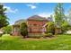 Brick home exterior featuring a wood deck and lush green landscaping at 7302 Yellowhorn Trl, Waxhaw, NC 28173