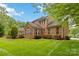 Exterior view of a brick home with a well-maintained lawn and landscaping at 7302 Yellowhorn Trl, Waxhaw, NC 28173