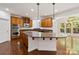 A kitchen featuring wooden cabinets, granite countertops, and an island with a marble top and pendant lighting at 7302 Yellowhorn Trl, Waxhaw, NC 28173