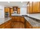 Wide angle shot of a kitchen featuring wooden cabinets, stainless steel appliances, and granite countertops at 7302 Yellowhorn Trl, Waxhaw, NC 28173