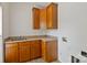 Laundry room featuring wooden cabinets, a sink, and laminate countertops at 7302 Yellowhorn Trl, Waxhaw, NC 28173