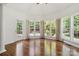 Bright living area with hardwood floors and multiple windows showcasing the outdoor view at 7302 Yellowhorn Trl, Waxhaw, NC 28173