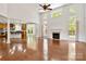 Open-concept living room with hardwood floors, a fireplace, and large windows, offering ample natural light at 7302 Yellowhorn Trl, Waxhaw, NC 28173