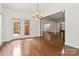 Living room featuring hardwood floors, a chandelier, and french doors leading to a patio at 7302 Yellowhorn Trl, Waxhaw, NC 28173