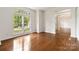 Bright living room featuring hardwood floors, a large window, and white trim, offering a view of the outdoors at 7302 Yellowhorn Trl, Waxhaw, NC 28173