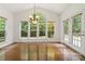 Living room featuring hardwood floors, a chandelier, and large windows overlooking a landscaped yard at 7302 Yellowhorn Trl, Waxhaw, NC 28173