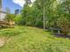 Lush backyard featuring a wooden deck, green lawn, and mature trees providing privacy at 7409 Tarland Ln, Charlotte, NC 28269