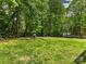 Large backyard featuring a wooded border with split rail fence and mature trees at 7409 Tarland Ln, Charlotte, NC 28269