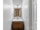 Chic powder room with modern vanity, updated fixtures, and stylish mirror at 7409 Tarland Ln, Charlotte, NC 28269