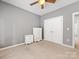 Bedroom featuring carpet, ceiling fan, closet, and two white dressers providing plenty of storage space at 7409 Tarland Ln, Charlotte, NC 28269