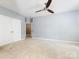 Large bedroom with carpet, ceiling fan, closet and an open doorway to another room at 7409 Tarland Ln, Charlotte, NC 28269
