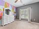Bedroom features a geometric accent wall, large window, and dresser with mirror at 7409 Tarland Ln, Charlotte, NC 28269