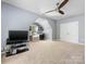 Bonus room features a TV, ceiling fan, built-in desk, shelves, and plenty of space at 7409 Tarland Ln, Charlotte, NC 28269